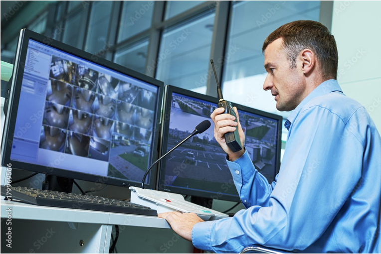 A man sitting at a desk with two monitors.