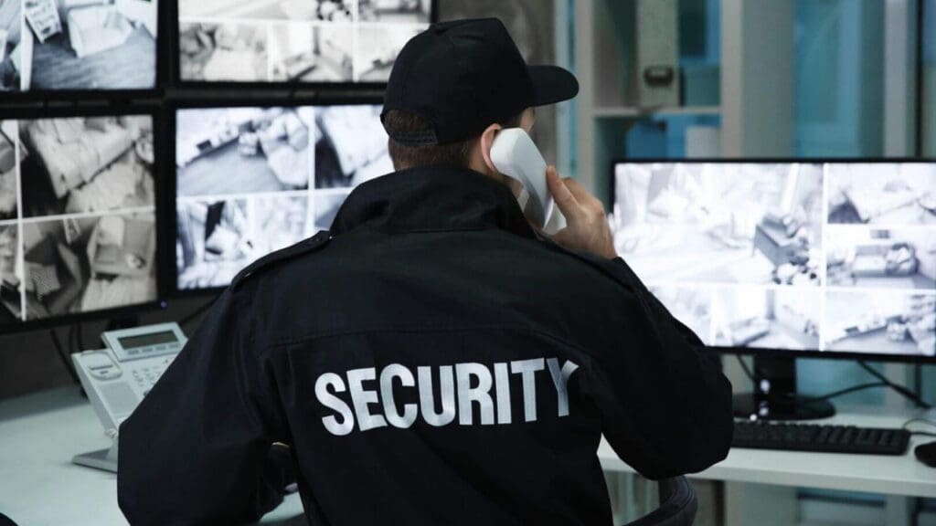 Security officer on the phone watching camera feeds on several monitors